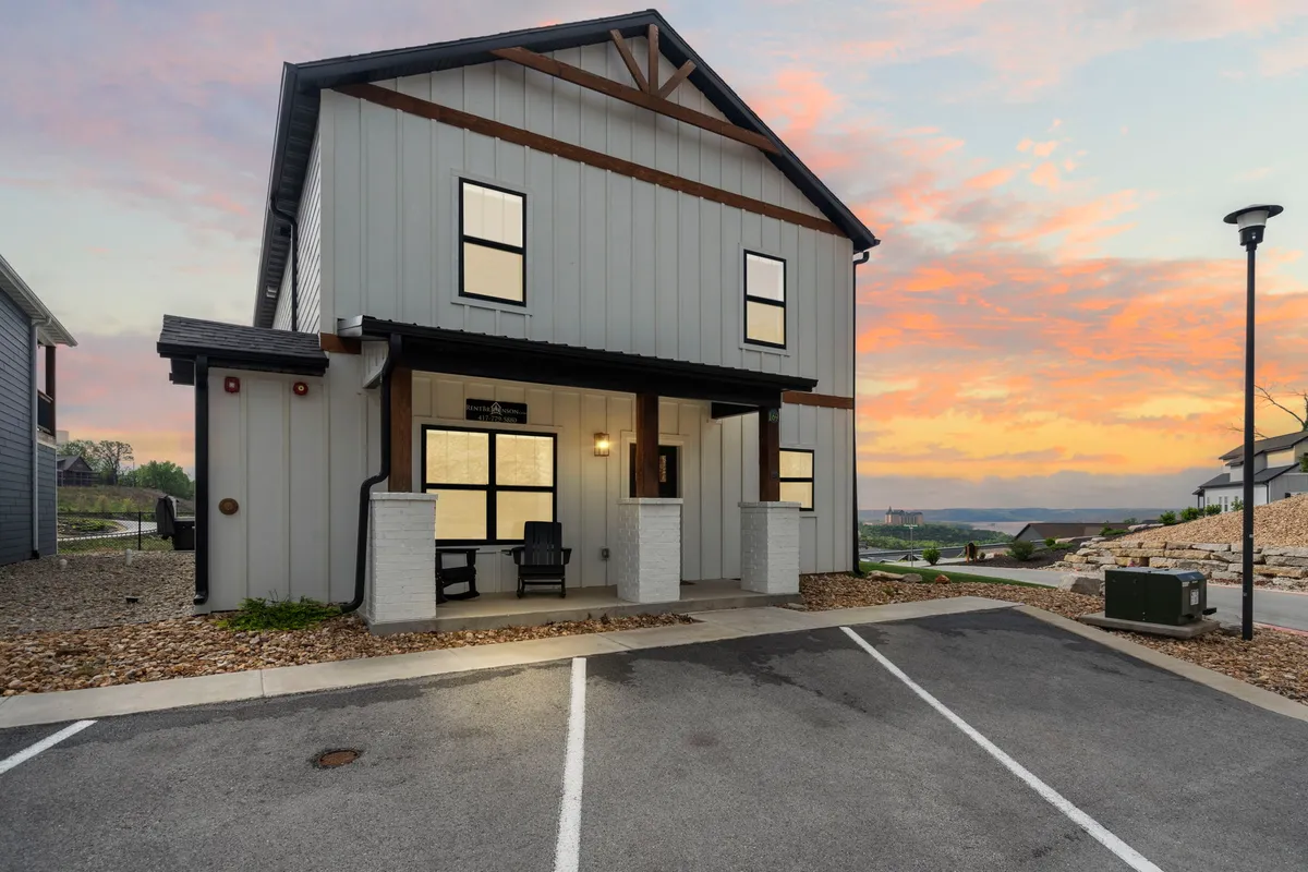 This exterior shot features a tidy front porch with large windows and a glowing sunset sky. The inviting setting offers a glimpse of tranquil outdoor living while subtly emphasizing exterior cleanliness and maintenance.