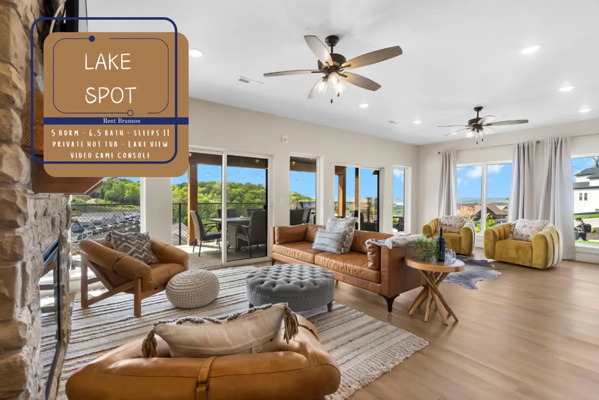 A spacious living room with comfortable seating, large windows offering a lake view, a stylish coffee table, and decorative throw pillows. The arrangement suggests a space ideal for family relaxation, game nights, or watching sunsets together.