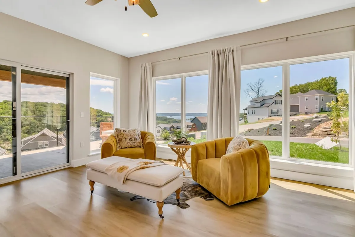 A sunlit lounge setting with large windows, yellow armchairs, and an ottoman. The seating is positioned to maximize enjoyment of the breathtaking natural scenery outside, creating a cozy nook perfect for reading or morning coffee while soaking up sunlight.